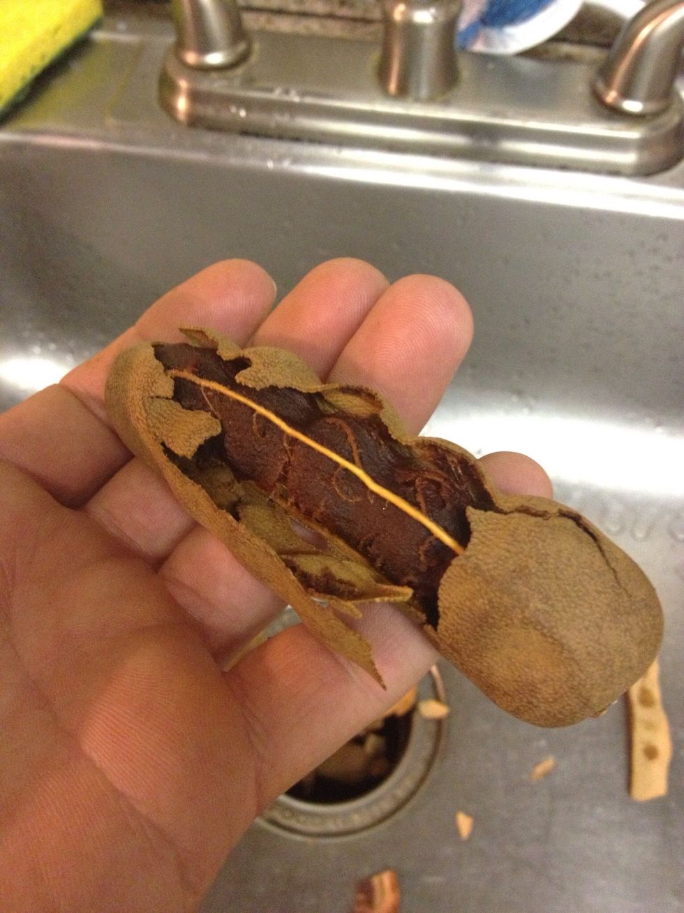 The dried shell cracks apart revealing the fruit. Remove as much of the shell as possible, don't worry if you miss some little pieces.