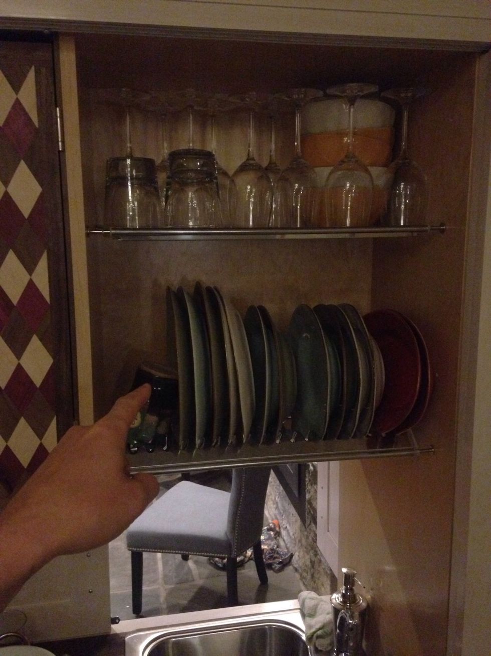 The drying rack is above the sink and also functions as a storage rack