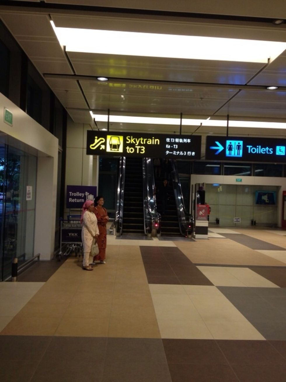 The escalator is just right beside the Quiznos stall. This will lead you to the SkyTrain to Terminal 3 where you can take the train to the city