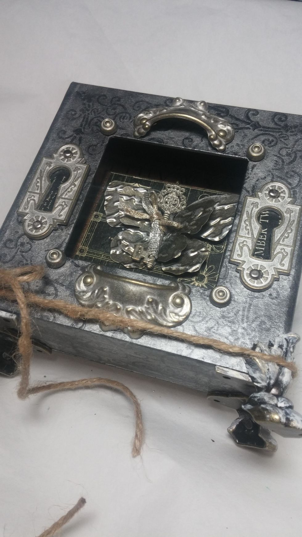 The feet were glued on as well. I used twine to hold them in place as they set. Also notice I added the brads in the corner.