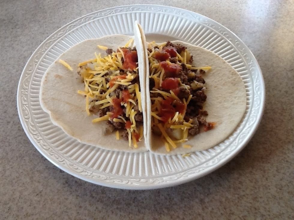 The finished product. On the tortilla, put a big spoonful of the meat, onions, and potatoes mixture, then add a little cheese and salsa.