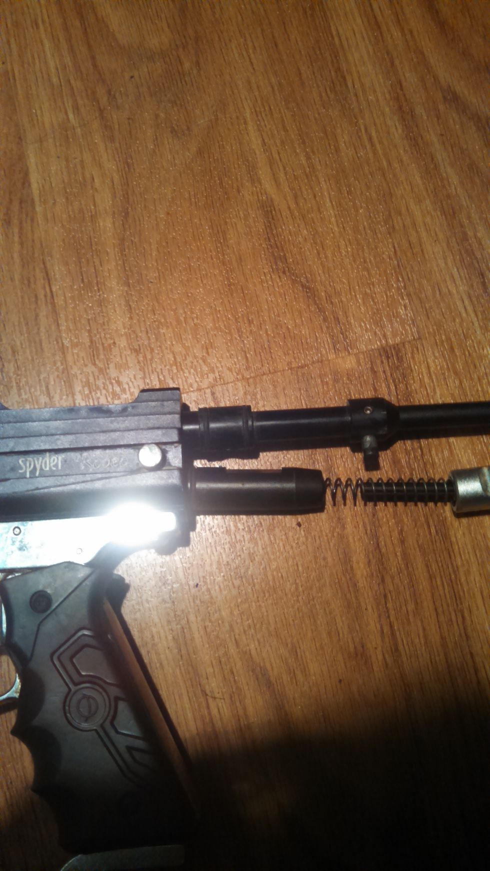 The first step in dissasembely will begin by pulling the  pin which holds in the bolt and the ram. This is the silver piece next to the Spyder logo. the bolt and the ram should pop out on their own.