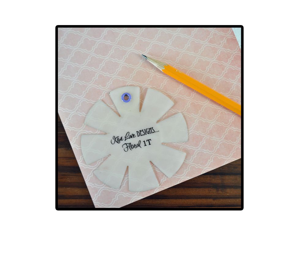 The first step is to choose some flower or other shaped Designer Templates to use for the top of the pen. Then using your patterned paper, trace and cut each one out.