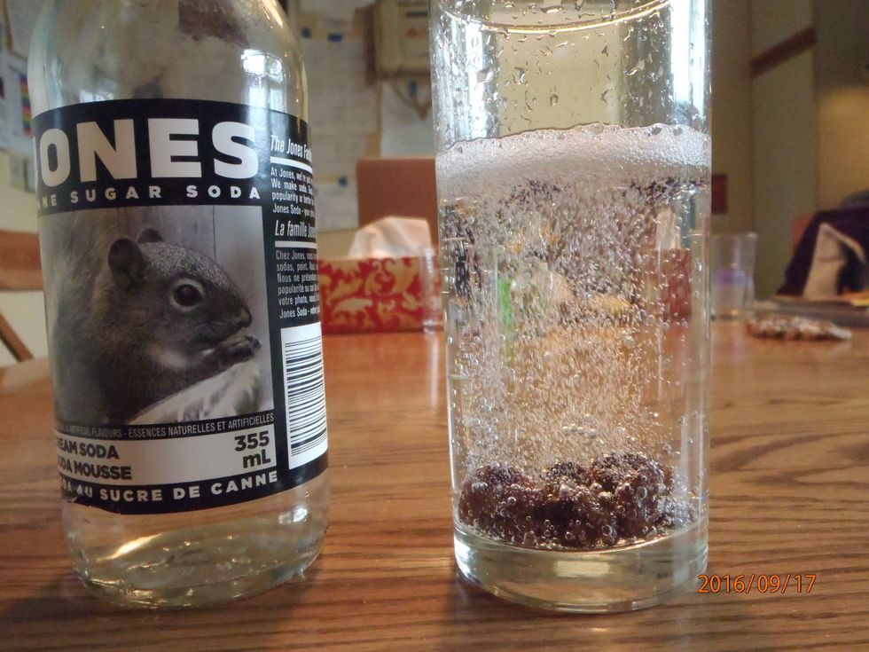 The fizz(carbon dioxide) in the pop drink attaches to the raisins.
