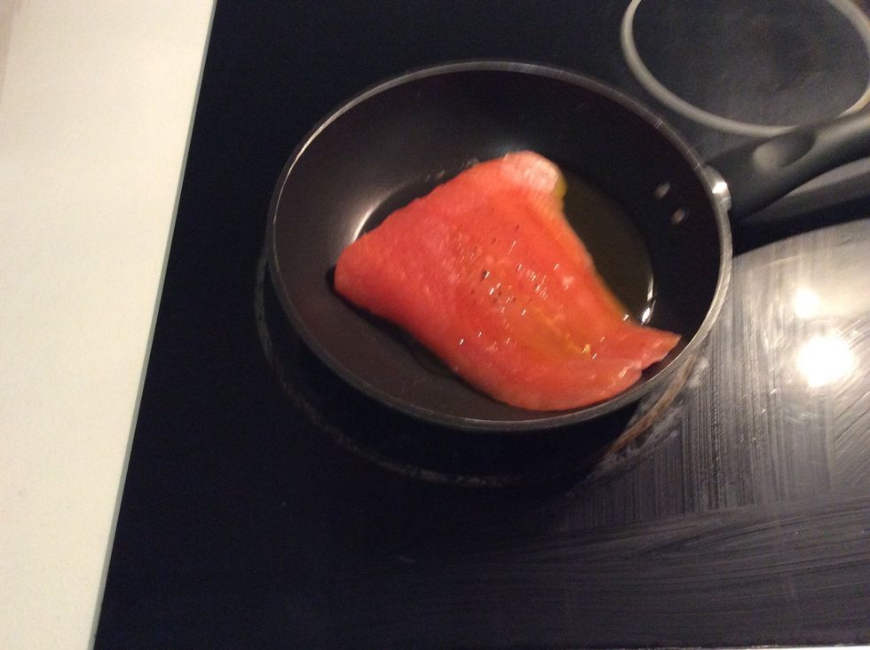 The fourth step is to place the salmon in a pan and drizzle a bit of oil on top