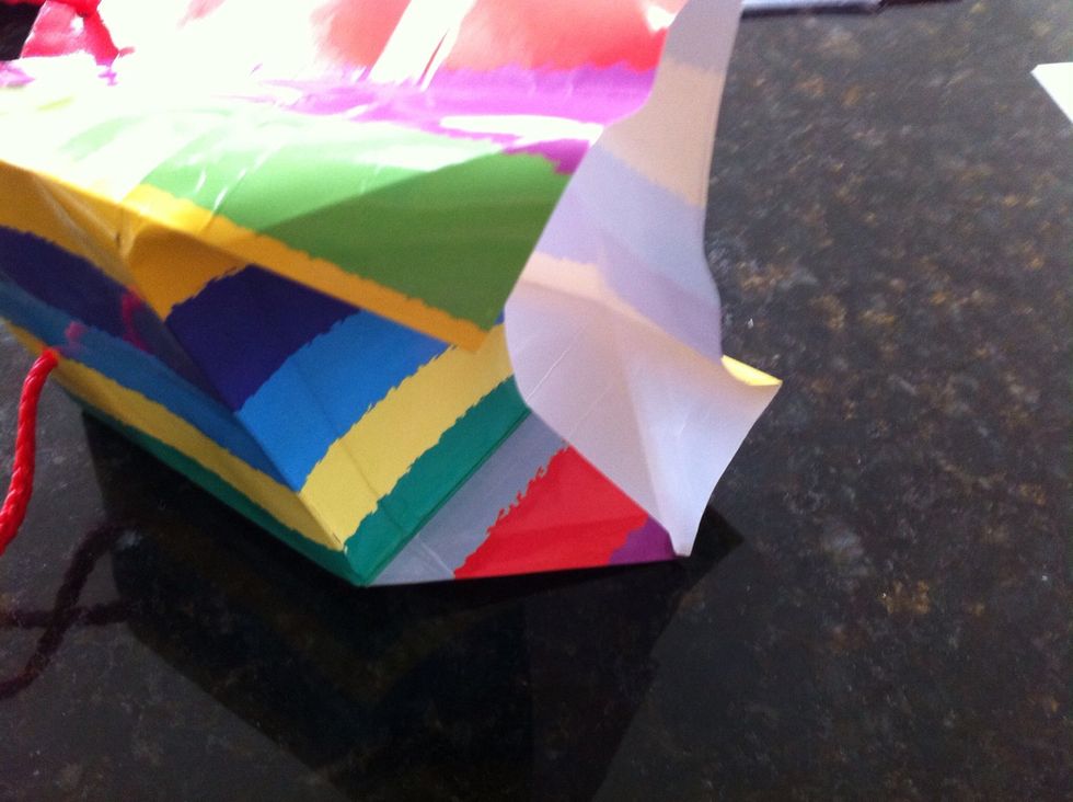 The hard bit: Lay the bag on it's side and fold the sides in, at 45 degrees. Half of one side is shown folded.