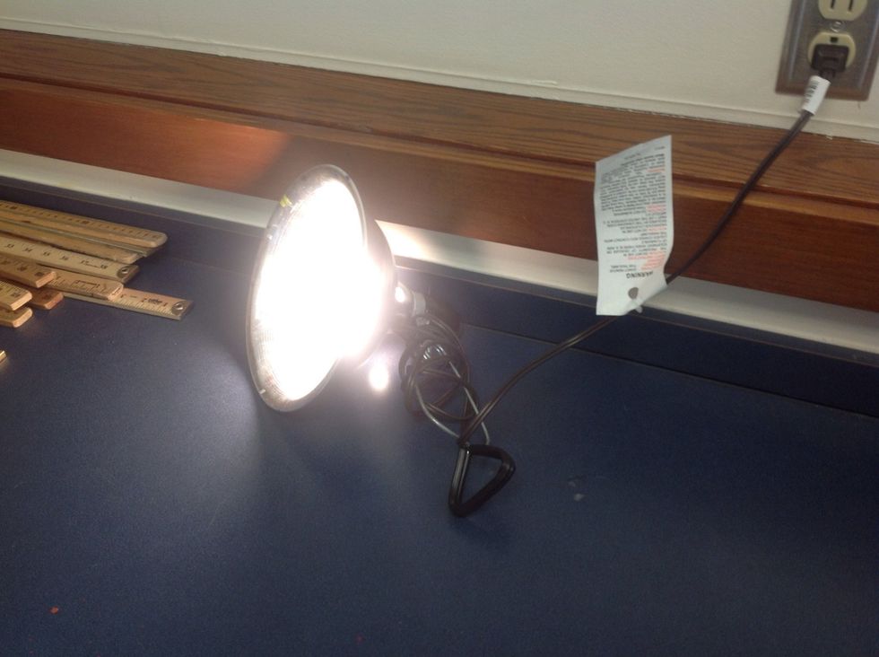 The heat lamp turns electrical energy into thermal and light energy when it is plugged in.