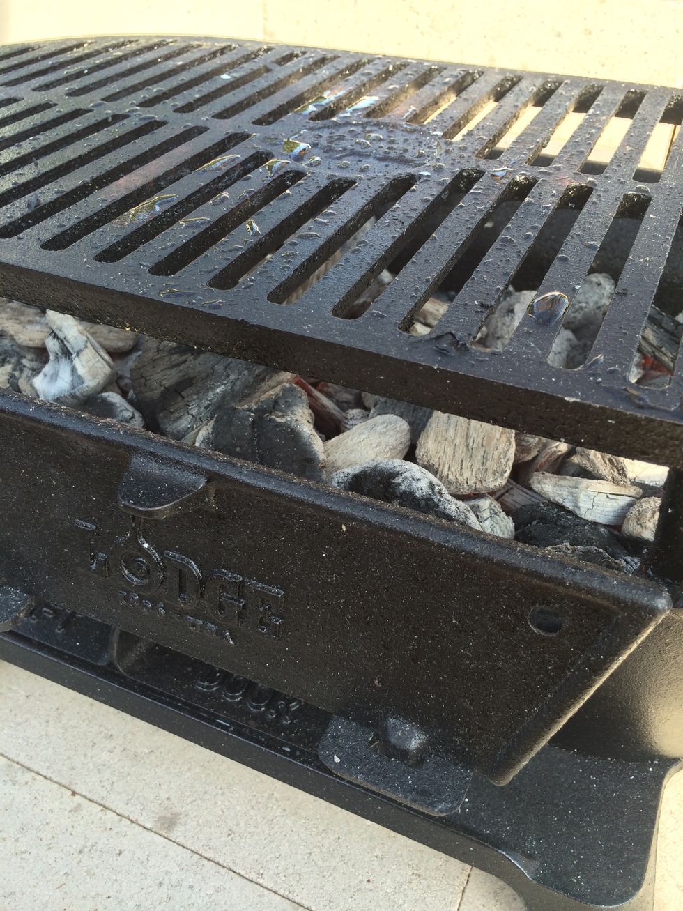 The hot coals have been added to the grill. I've also oiled the grilling surface, and now wait several minutes for the cast iron cooking surface to get hot.
