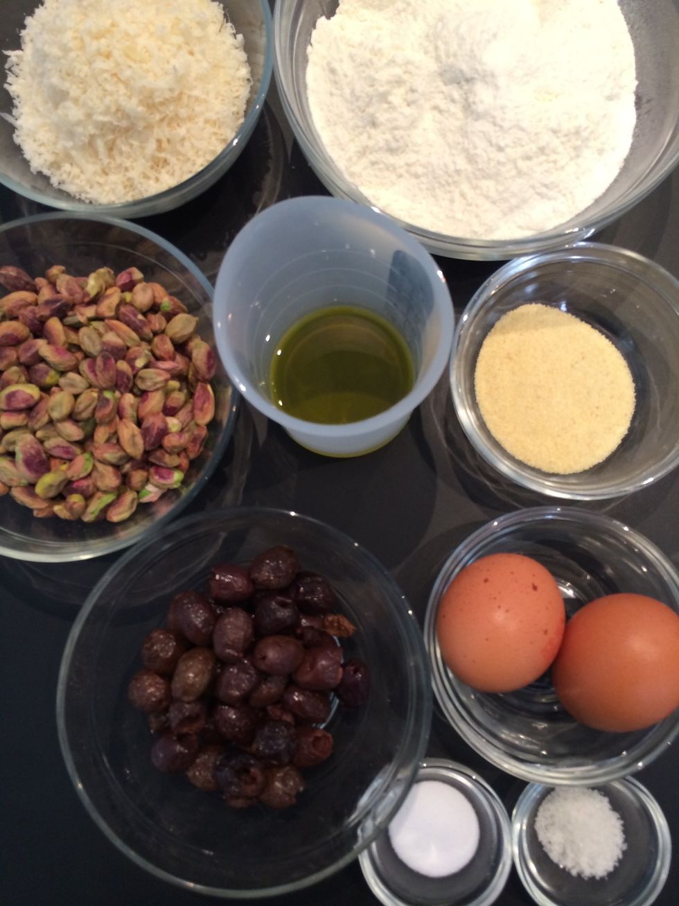 The ingredients flour, semolina, grated Parmesan, black olives, pistachios, olive oil, eggs salt and baking soda