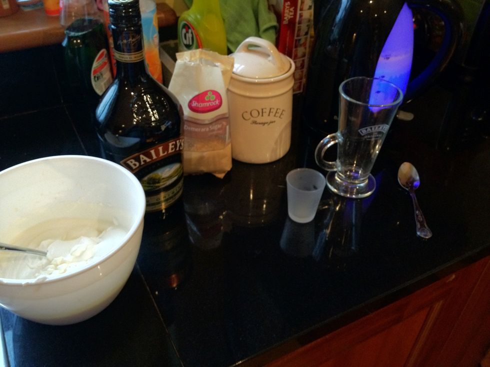 The ingredients, remember to heat the glass. 2 tsps of coffee, one tsp of brown sugar, pour water in and stir. Leave room for one shot of baileys, then add the freshly whipped cream.