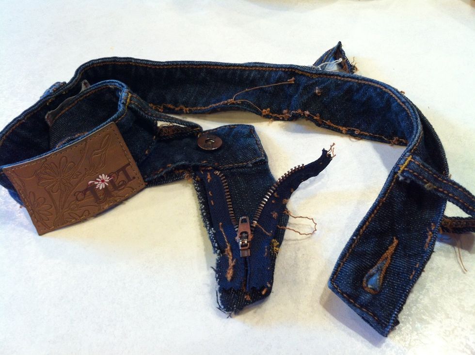 The jeans must fit you well when zipped up all the way, even if you cant button them. Carefully rip off the entire waistband and zipper, leaving the part of the jeans that used to hide the zipper.