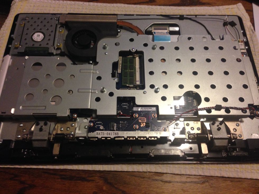 (The leg support mechanism x 2 are still pictured in this photo) Remove the screws holding the USB/power circuit board. A gentle upwards pull will remove it from the motherboard.