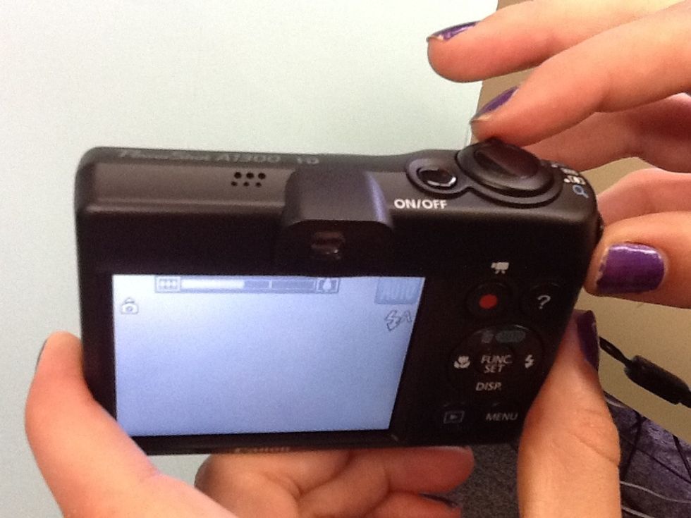The lever around the shutter button is how you zoom in and out to capture a closer picture.