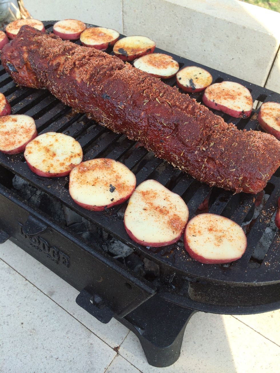 The loin has been placed on the hot grill. Leave it alone & untouched for 5 minutes before turning it. I've added sliced red potatoes to the grill too, they are also oiled and seasoned w/ BBQ dry rub