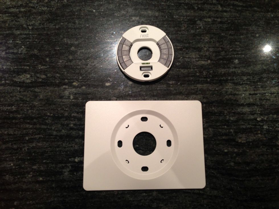 The Nest comes with a base (top in pic) and an optional trim plate (bottom in pic). The trim plate is useful to cover up holes or marks left by your old thermostat.
