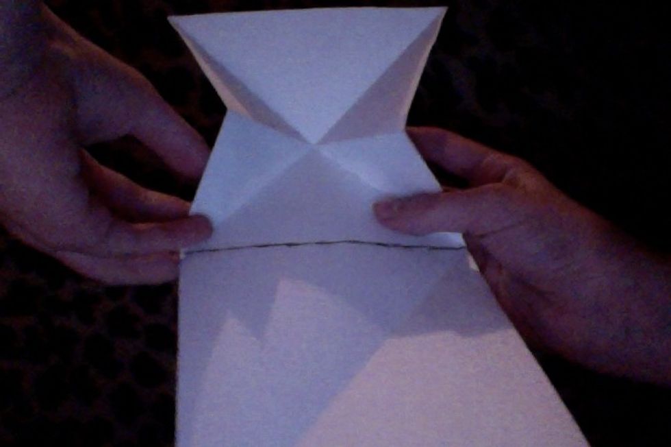 The next part is a bit hard to explain: First, you need to flip the paper back over. You will be creating a triangular base with the creases that you just made.
