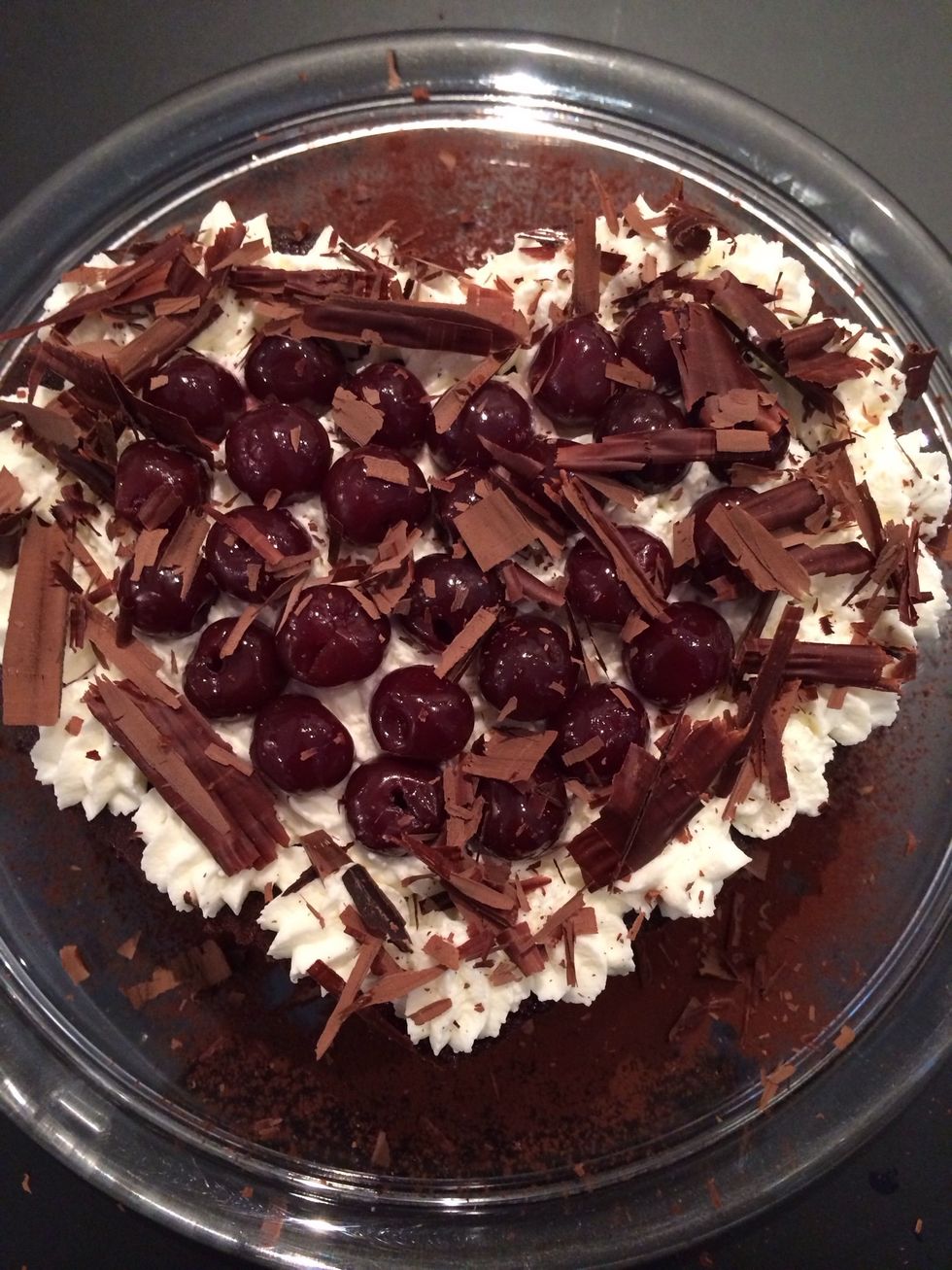 The original recipe is finished with the whiped cream covering the whole cake and decorated with some cherries and chocolate shave.