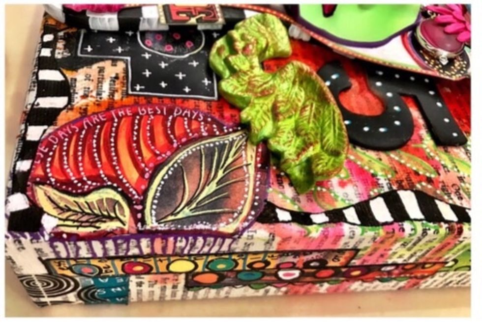 The paintbrush is used as the base to help me raise the face and have a place to attach the ephemera. It is my focal