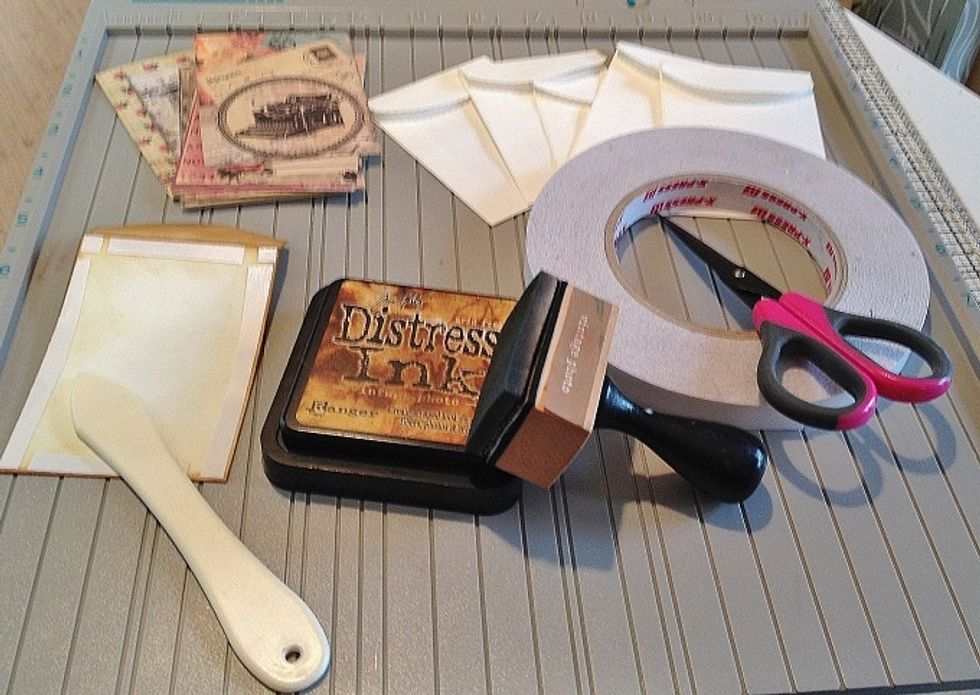 The patterned paper was cut to ATC size (2.5" x 3.5") and inked with vintage photo Distress Ink. I applied strips of double stick tape to the outer edges to adhere the paper to.