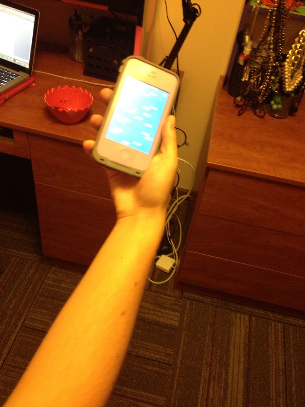 The red ball must land on a green platform to be propelled higher on the screen. To move the ball left and right, client must tilt the screen in the direction they want the ball to go.