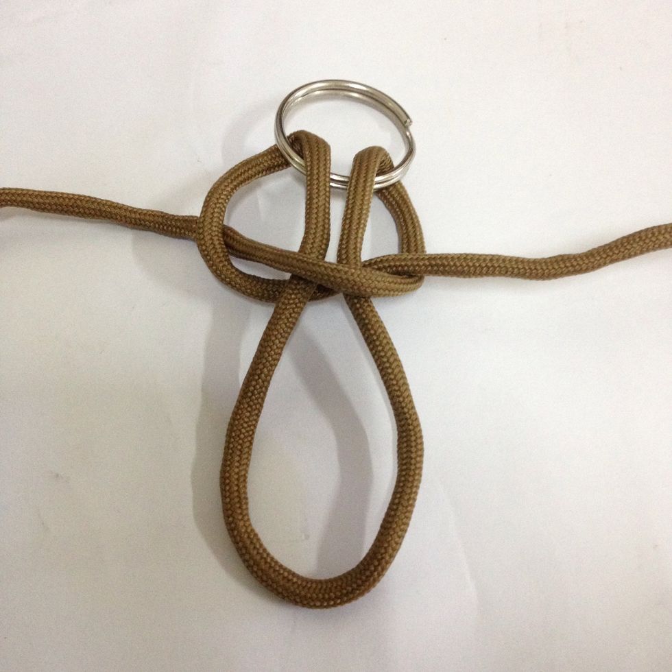 The right end goes infront of the loop to the left. And left end goes in front of the right end but comes out to the back of the loop.