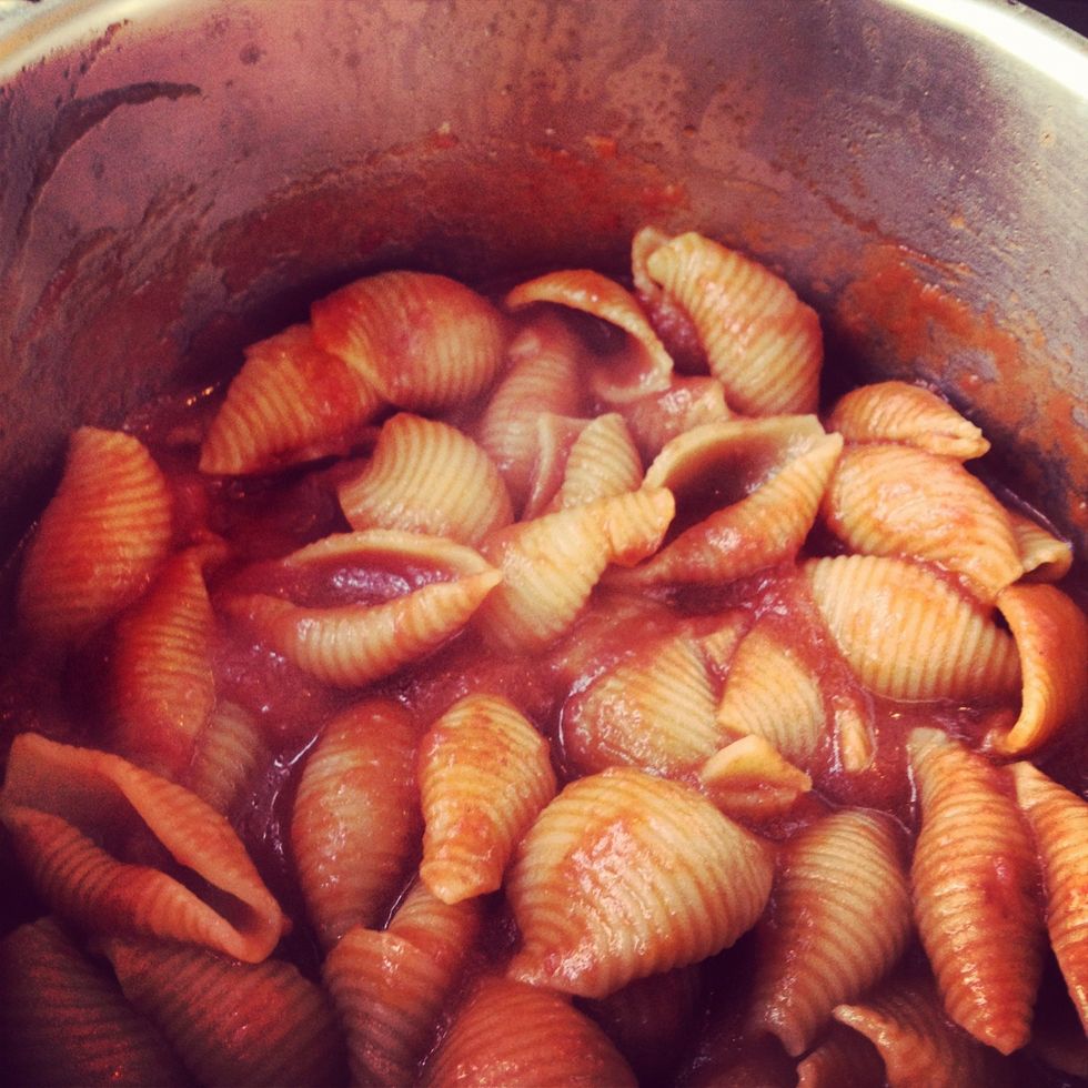 The sauce will thicken and reduce quickly. This is how it looks when it's done. Pasta absorbs the tomato sauce liquid: more tasty than water, ha? Take off the carrot, basil and, above all!, garlic :)