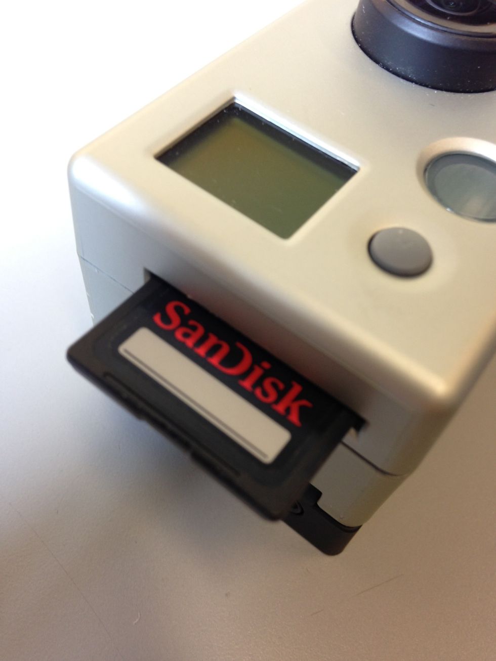 The SD card should slide into the side of the camera. You should hear a click once it is in place.