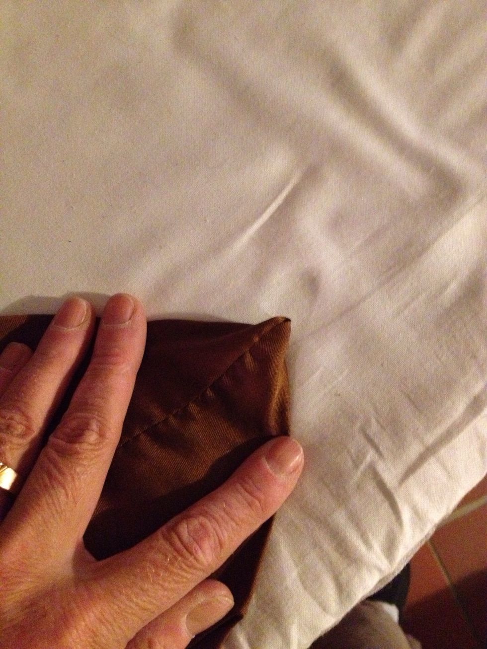 The seam between my fingers are the side seam. Fold the corner like this.