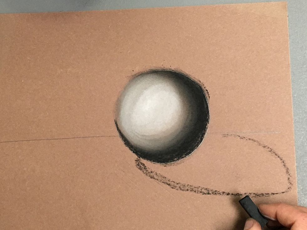 The shadow will be opposite source. Draw an oval representing the shadow. Make sure it begins directly under the circle and does not go above the horizontal line.