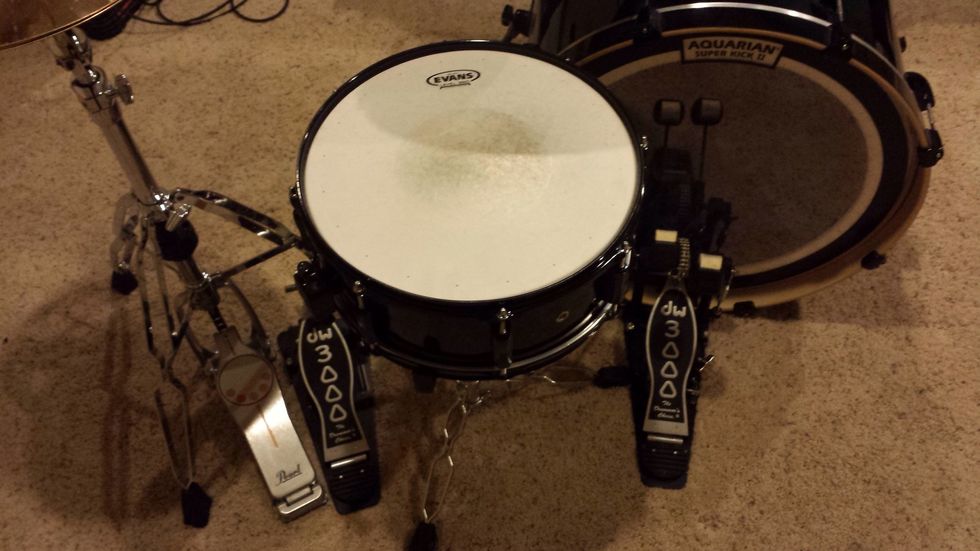 The snare drum fits in between the two bass pedals and should be level to your lap when sitting down at the set. This may be a tight fit, so rotate and adjust the legs of the stand until it fits.