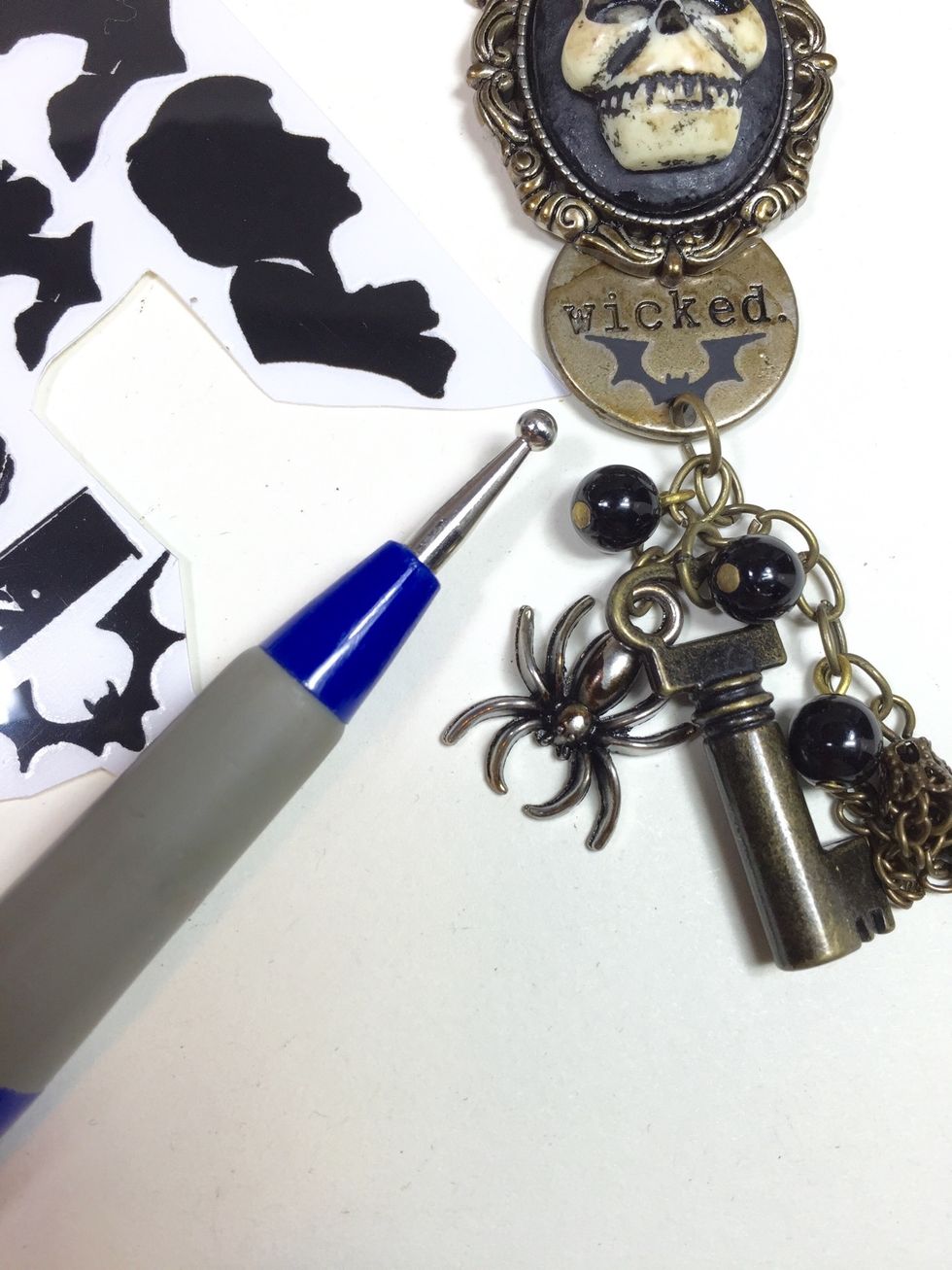 The space below the word "Wicked" on the word token needed something. This is a good place to put a rub-on. I used this small bat. These Halloween remnant rubs are by Tim Holtz as well.