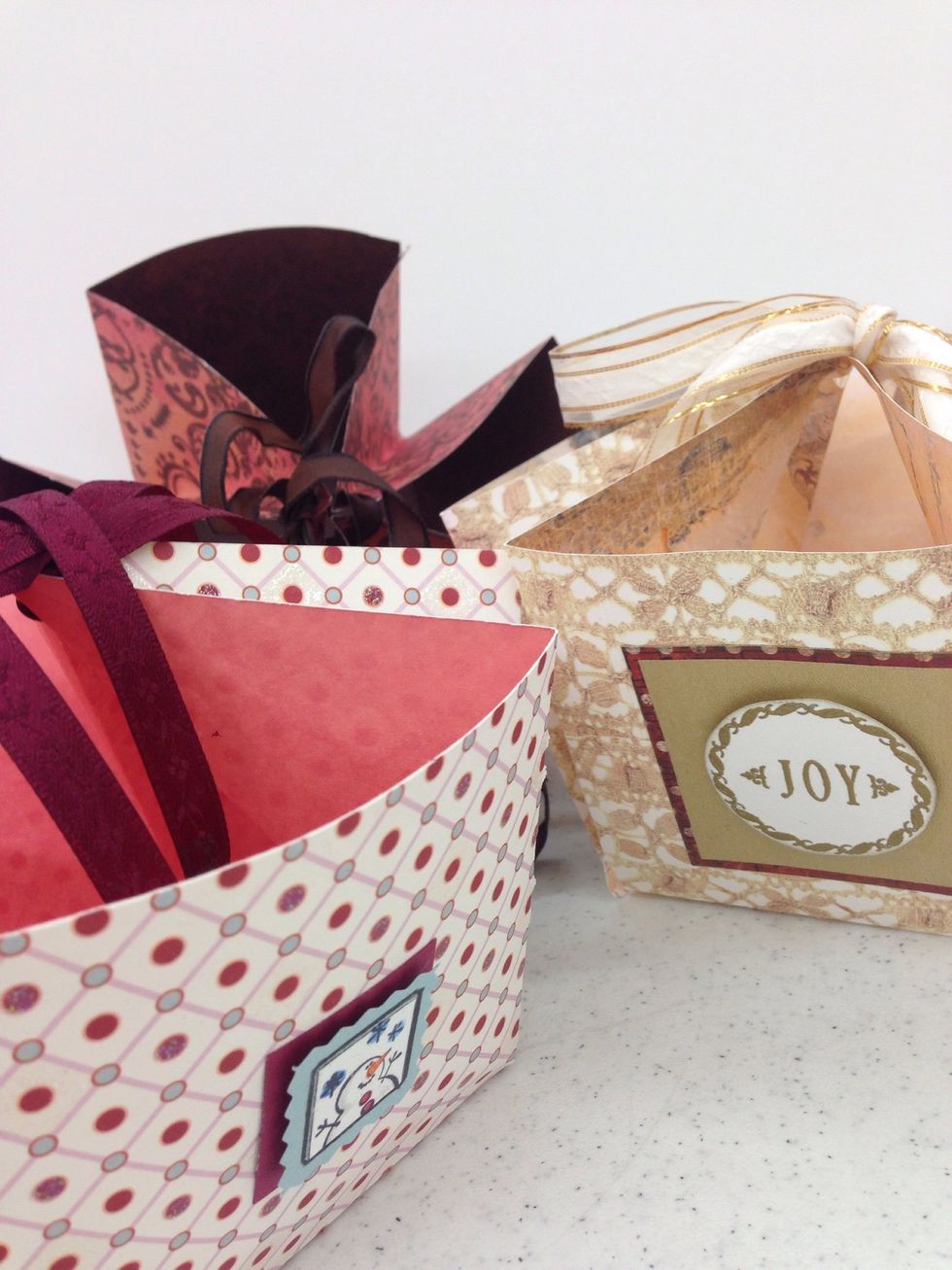 The square sides of the basket are a great place to add embellishments. Draw pictures, use rubber stamps, add flowers or other bling before folding and tying the basket.
