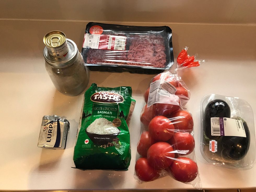 The supplies, Lebanese herbs, tomato paste, a pack of tomatoes, 7 aubergines, butter, 2 cups of rice, 500g of beef lean mints, knife and a scraper