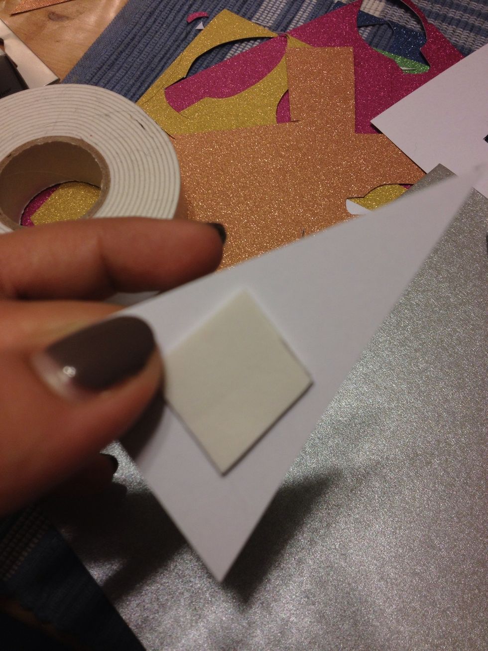 The tape has a sticky side and a covered side. Put the sticky side on the cutout.