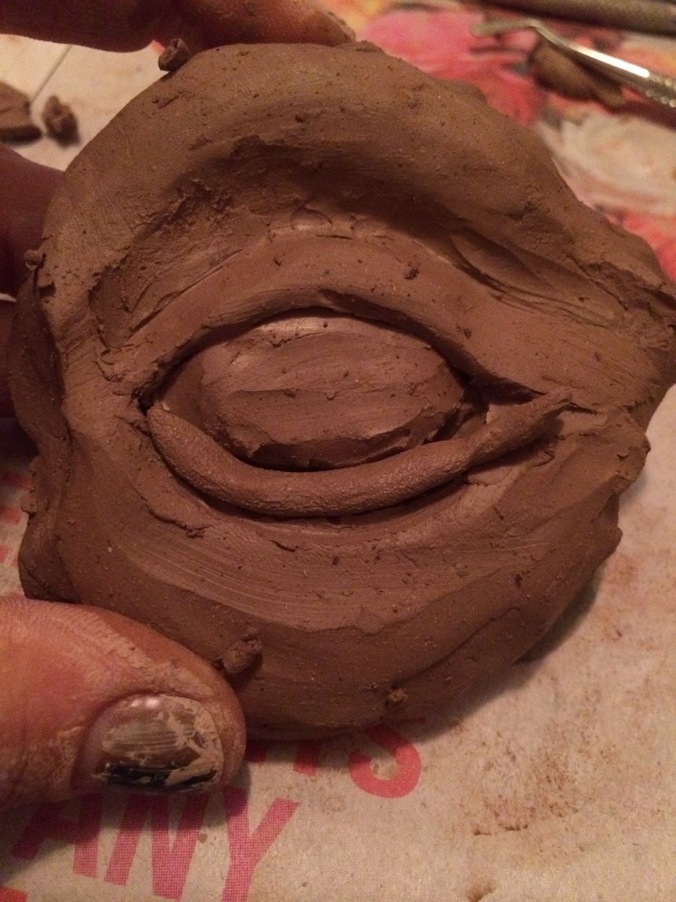 The third coil will be added to the bottom of the eye to act at the lower eye lid. Smooth out the bottom of the coil where'd it attaches to the cheek.