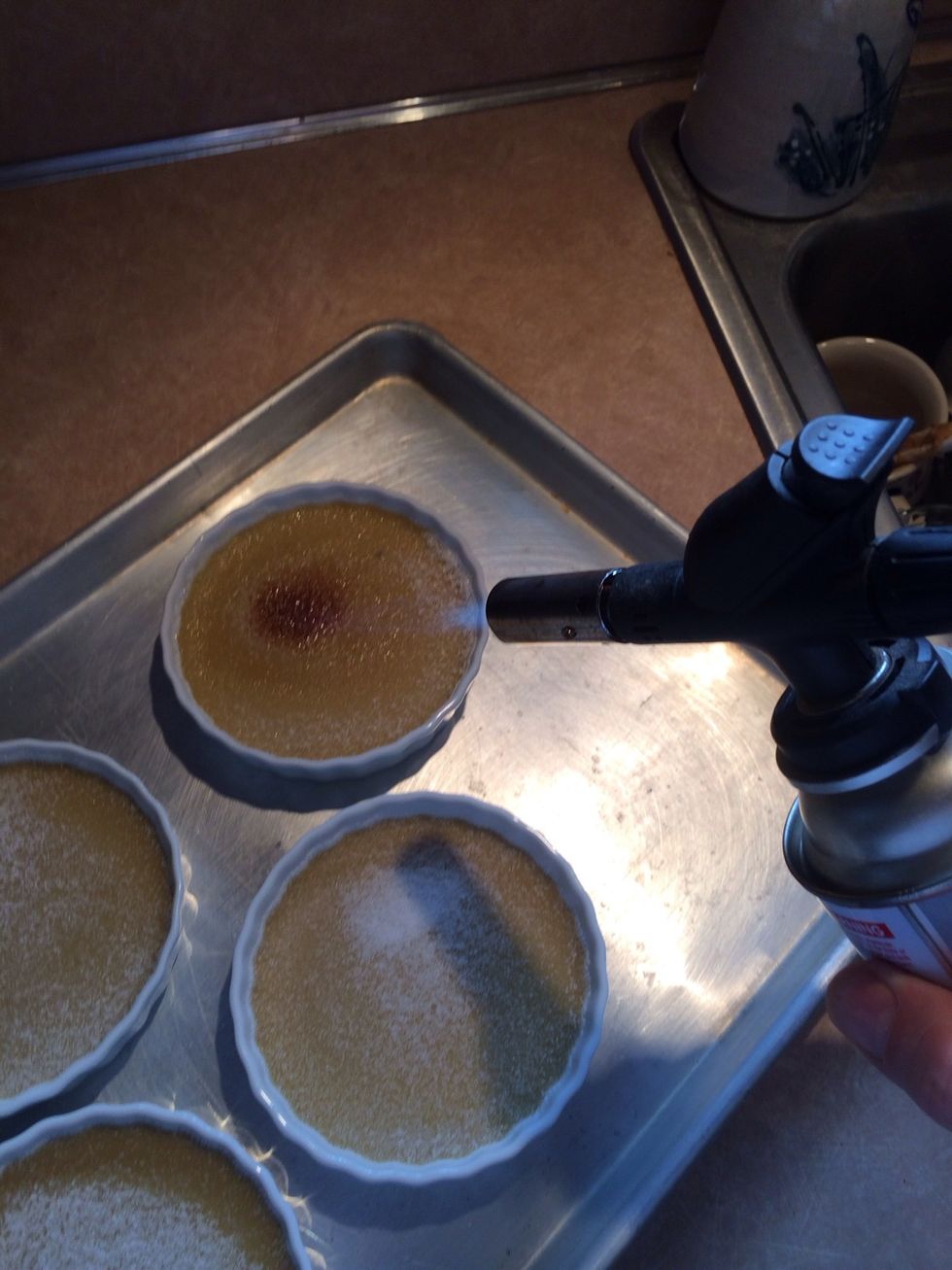 The tricky part... to burn the sugar on the tops of each custard. This is a small hand held food service grade br\u00fbl\u00e9e torch.