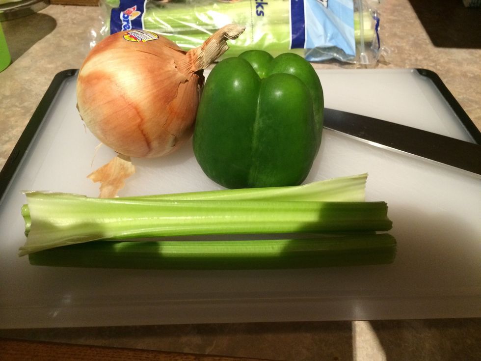 The Trinity! This is a must for gumbo. Chop onion, green pepper, and celery. In a big pot with a little oil in it start cooking the trinity.