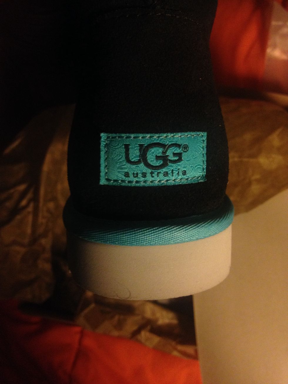 The UGG\u00ae trademark is on the shoe. My shoes were black with a blue(almost a Tiffany's blue) trim, so the tag is the same color as the trim. If you have shoes with a pink trim, pink tag.