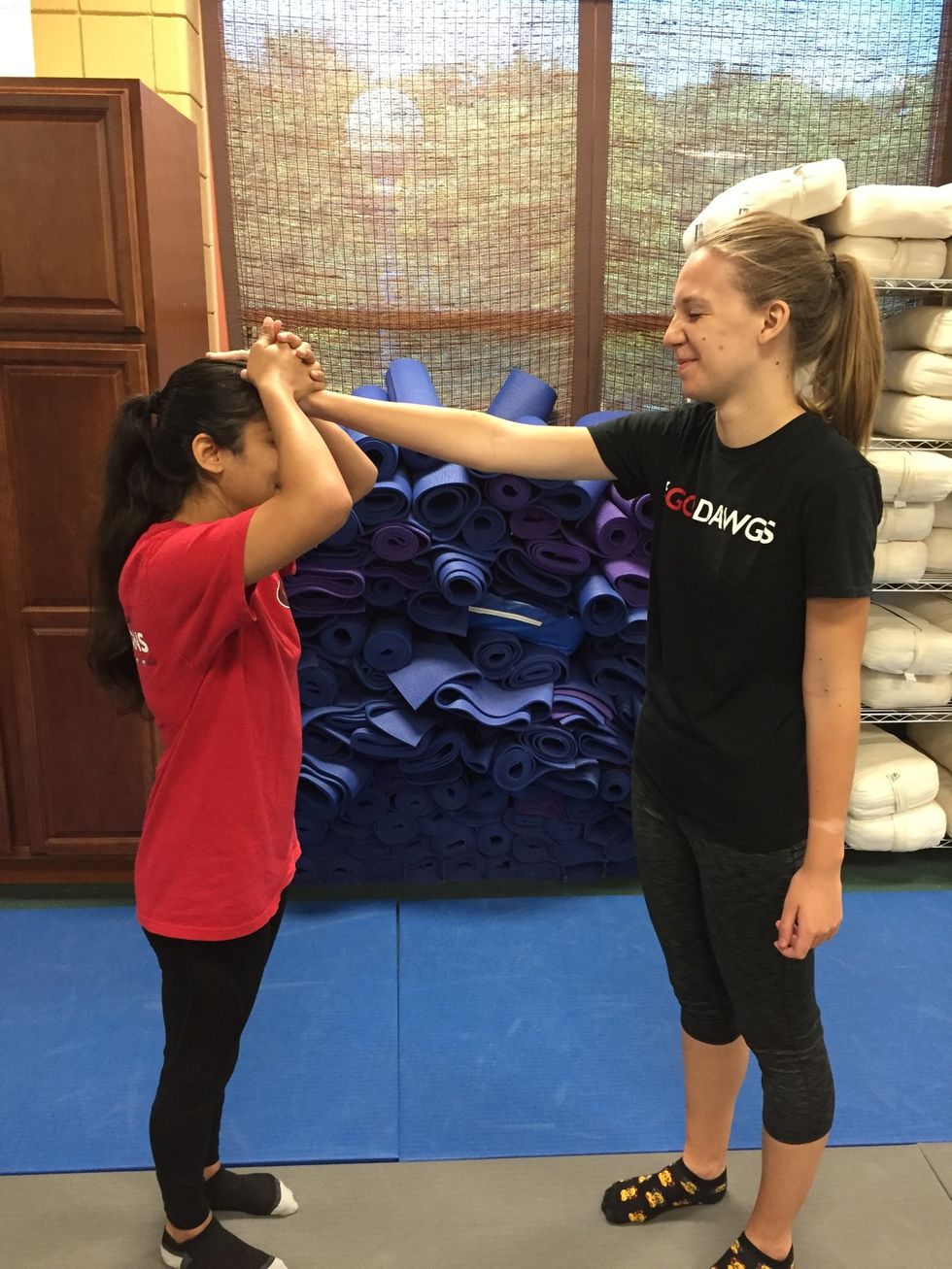 The victim interlocks fingers and presses hard down on forehead to flatten assailants hand