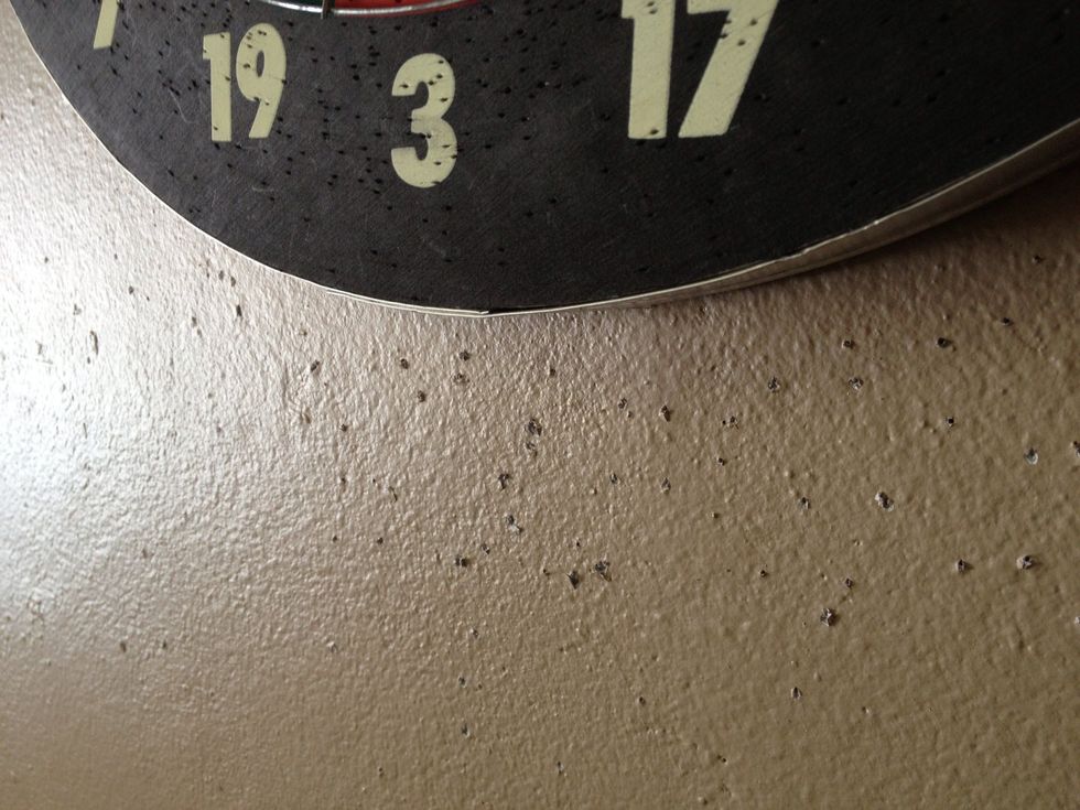 The walls are concrete so when a dart would miss the board, this is what would happen, and it's not too good for the darts either