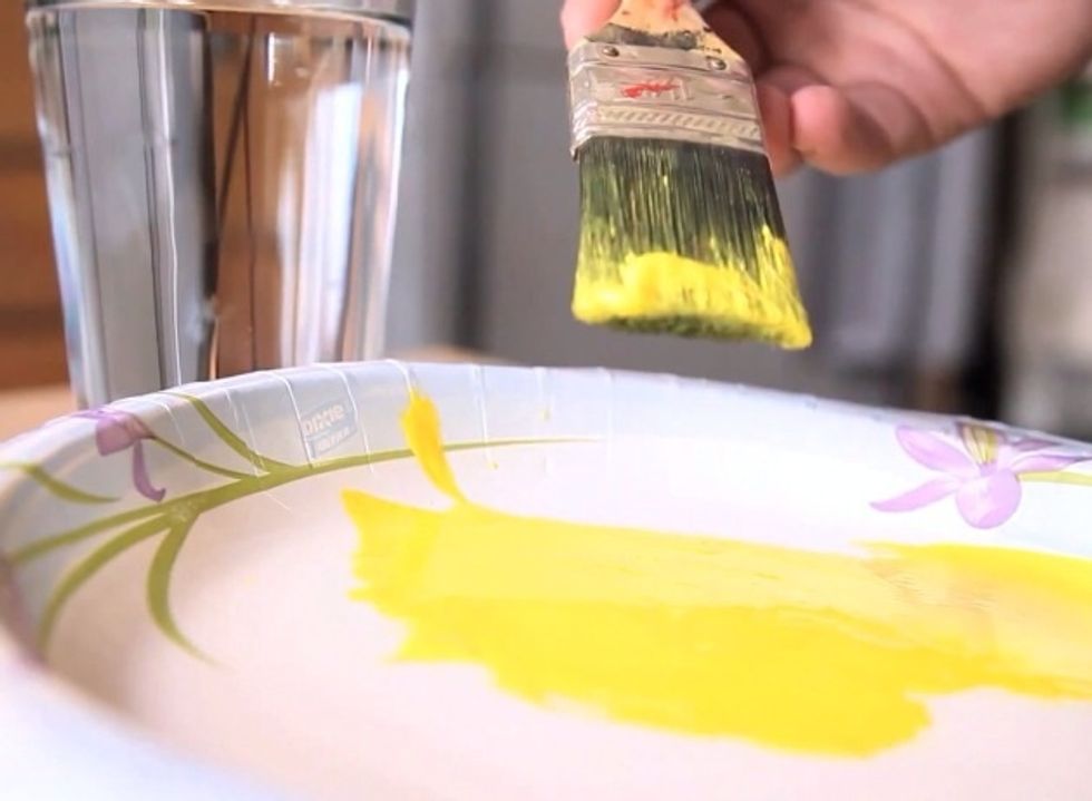 The water will actually coat the bristles, and make it harder for the paint to stick to the brush.