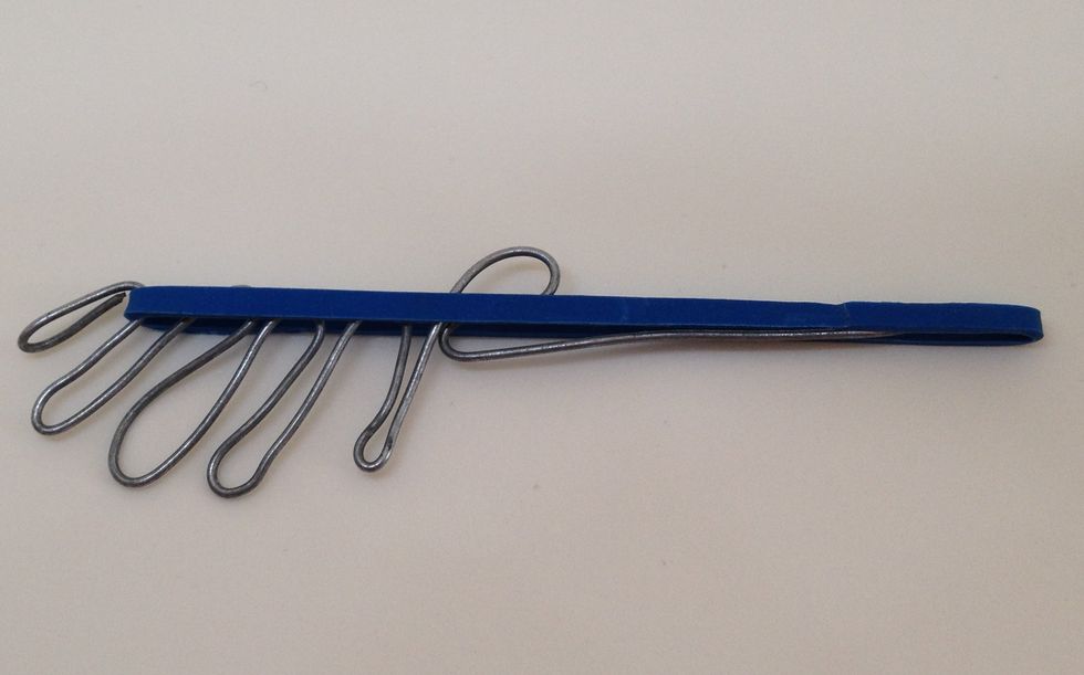 The wire tool needs to be bent into a shape that allows you to place a slightly stretched rubber band and keep it in position. This is used to insert the first band through the eye of the swivel.