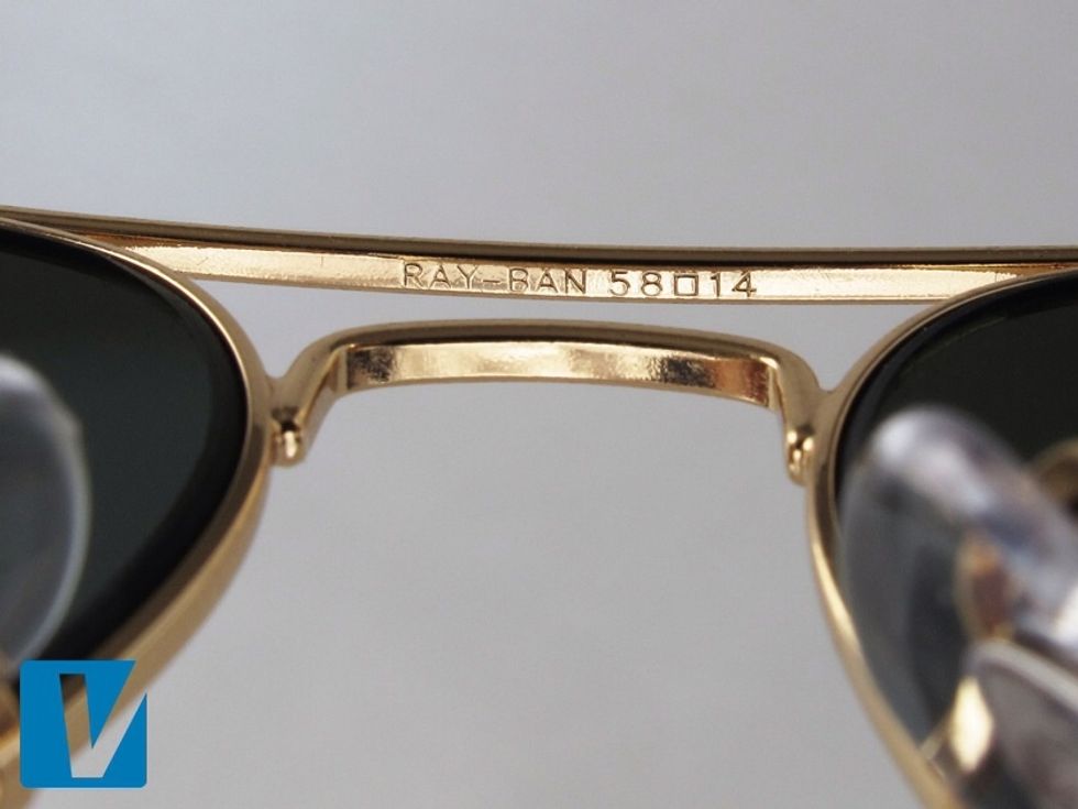 The word 'Ray-Ban' followed by the size code are located on the underside of the metal nose bar. Check that the code matches the size code detailed on the inside left temple arm.