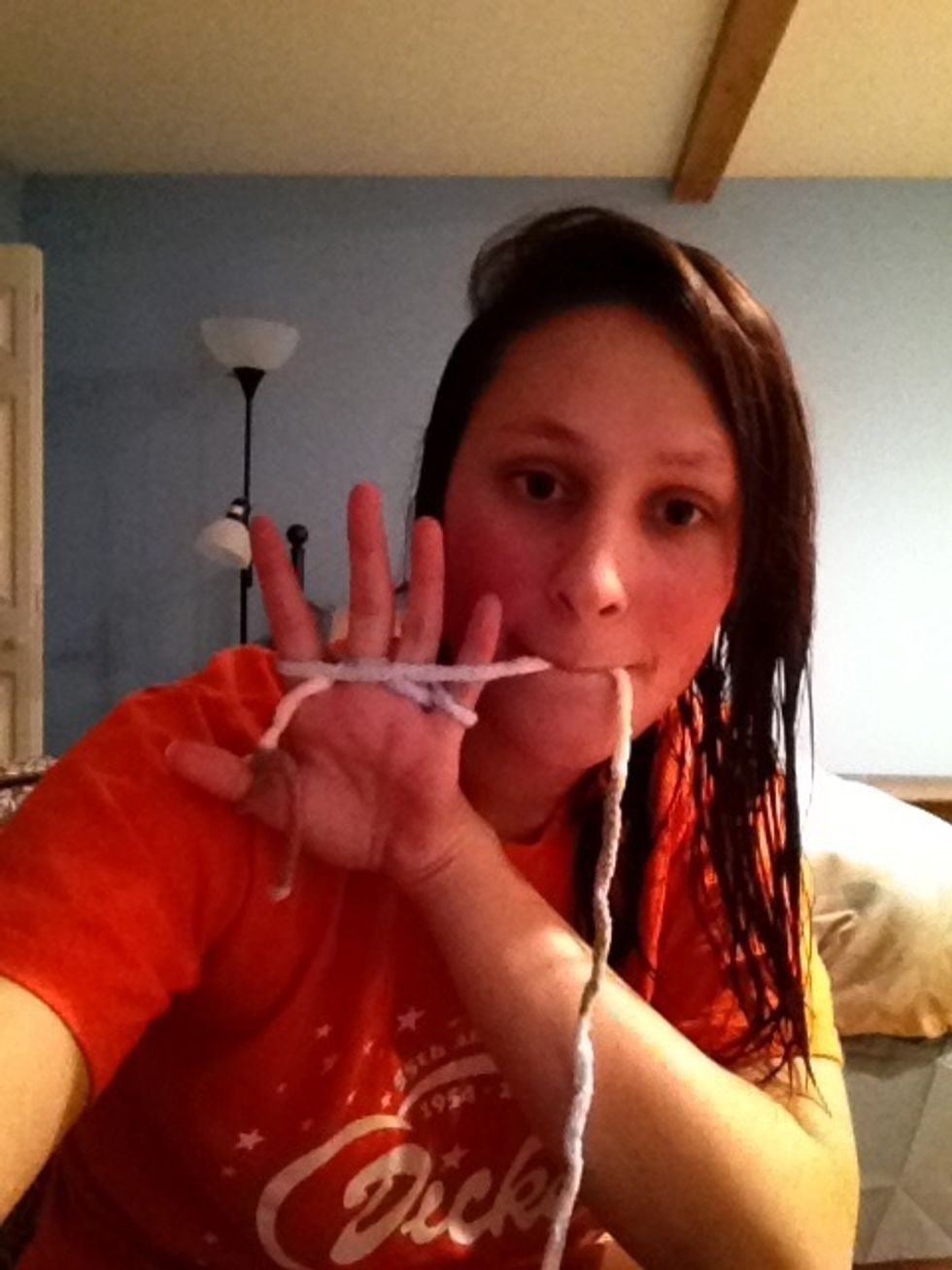 The yarn should run across your four fingers and hang by your pinkie finger again.