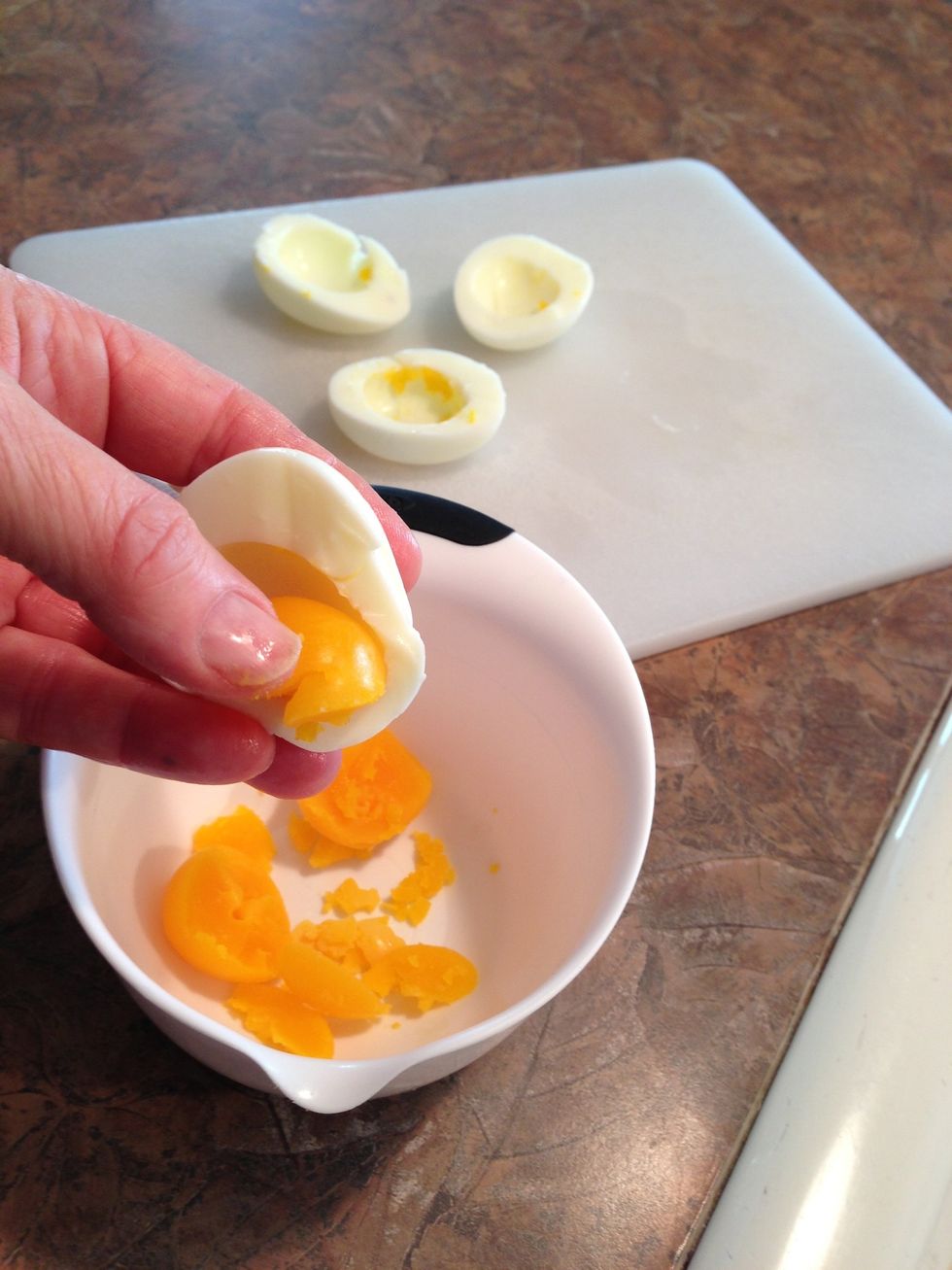 The yolks usually pop out easily. Don't worry if a little is left behind.