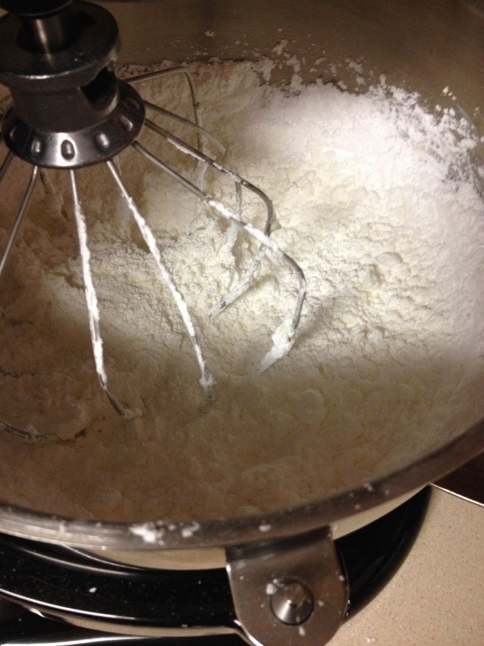 Then add about 4 cups of the icing sugar and mix on LOW until crumbs form and then add vanilla