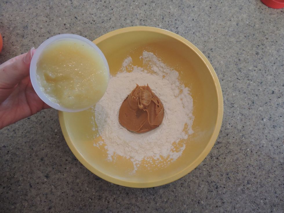 Then, add apple sauce to the mixing bowl.