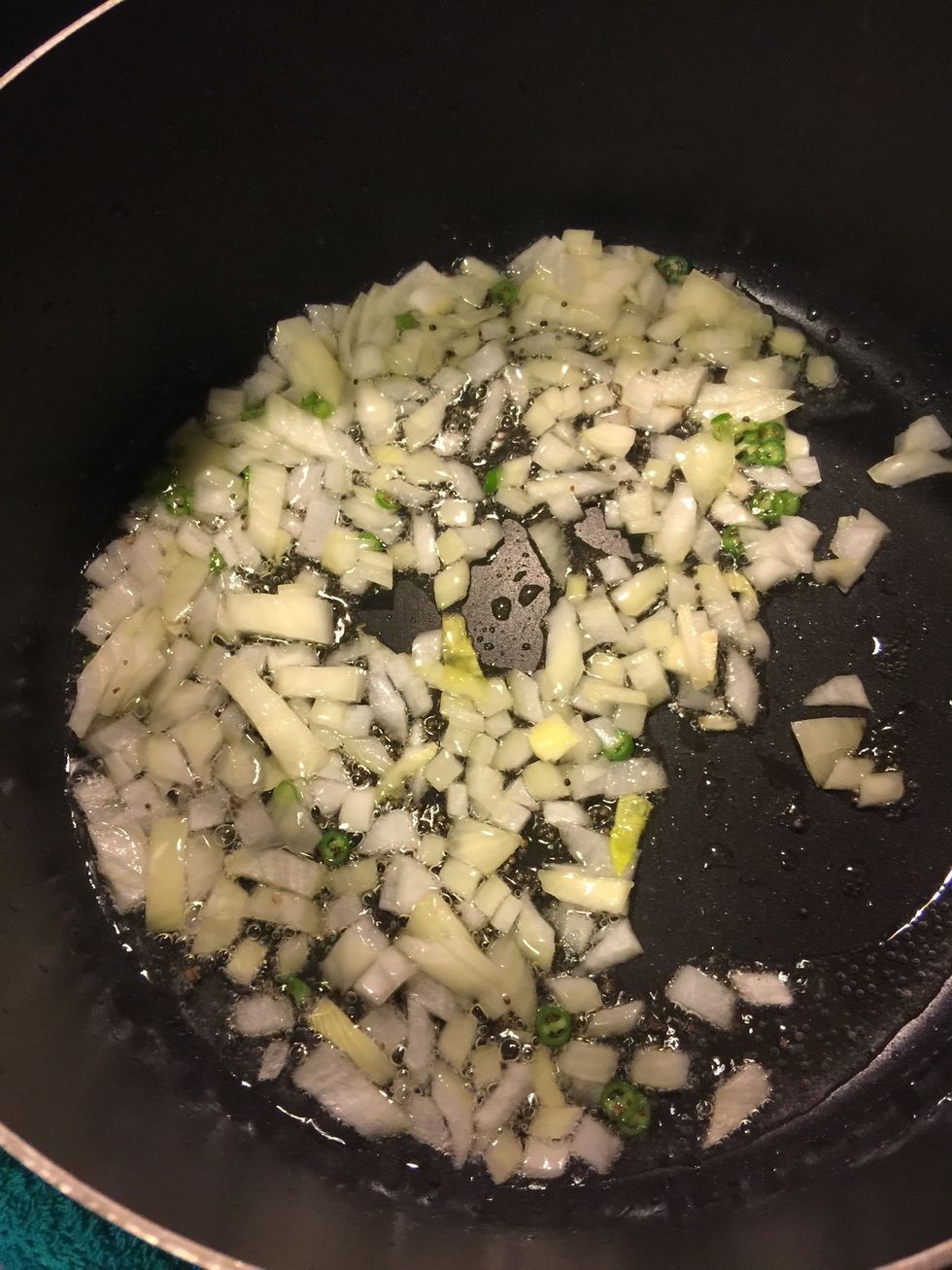Then add chopped onion and chillies and fry.