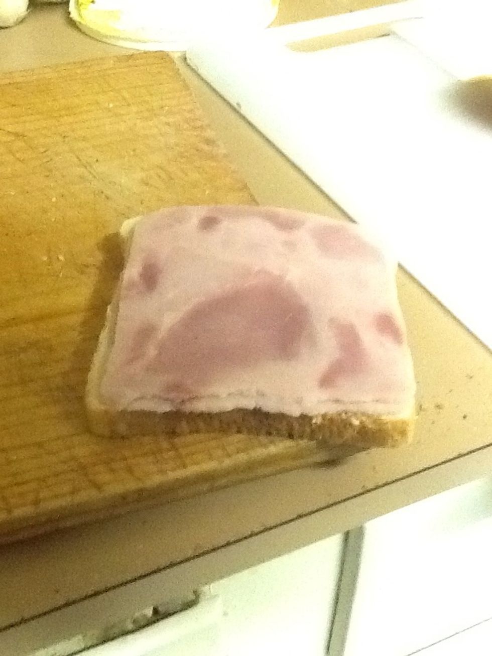 Then add ham to one slice of bread.
