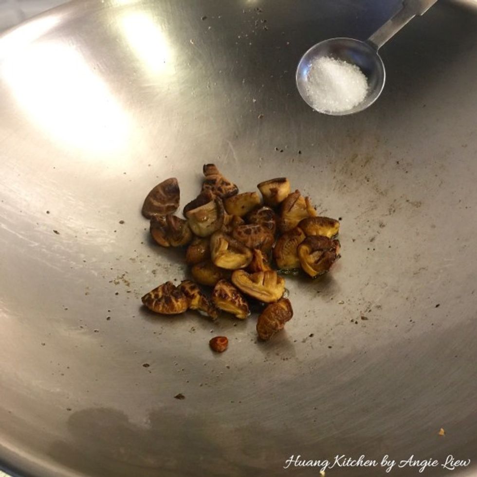 Then add in 1 tbsp sugar. Stir fry the mushroom caps till fragrant.
